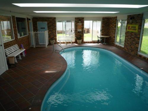 a large swimming pool in a large building at Kinross Inn in Cooma