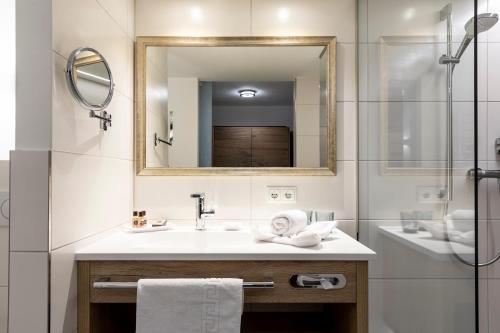 a bathroom with a sink and a mirror at GenussHotel Sonnblick in Sankt Leonhard im Pitztal