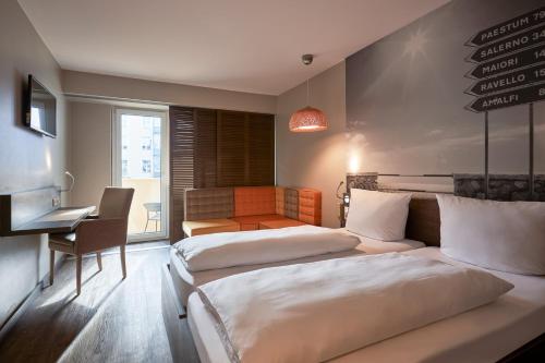 a hotel room with two beds and a desk at Hotel GIO in Munich