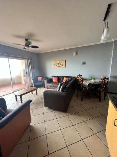 a living room with a couch and a table at L’Escalier Cabanas 510 in Amanzimtoti
