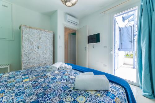 una camera con un letto blu e bianco e una finestra di Appartamento Playa Lapillo a Nardò