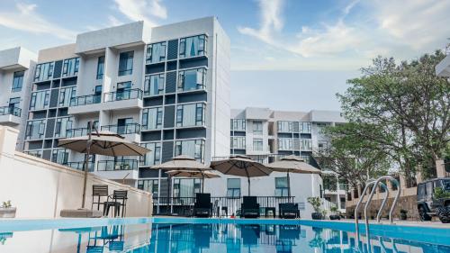 a hotel swimming pool with umbrellas and a building at Elizabeth Golf Apartment in Kigali