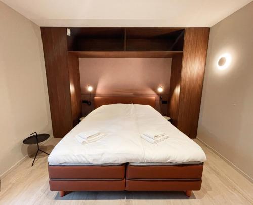 a bedroom with a bed with a wooden headboard at Hello Zeeland - Studio's Duinenburg 10 in Domburg
