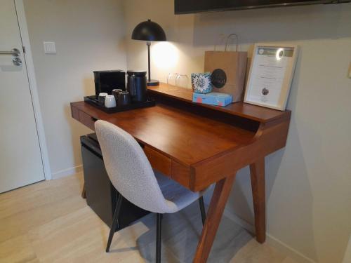 a wooden desk with two chairs in a room at Hello Zeeland - Studio's Duinenburg 10 in Domburg