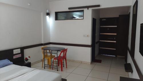 a bedroom with a bed and a table and two chairs at CBC Residency, Karjat in Karjat