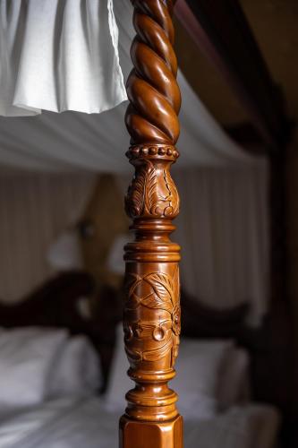 a wooden pole with a lamp on top of a bed at Park Hotel Linköping Fawlty Towers in Linköping