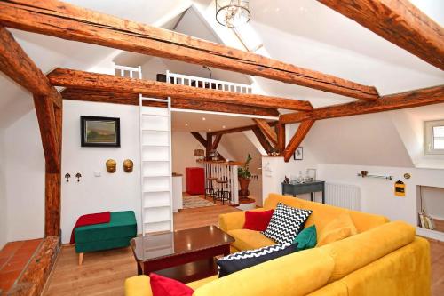 ein Wohnzimmer mit einem gelben Sofa und Holzbalken in der Unterkunft City Center Apartments in Prag