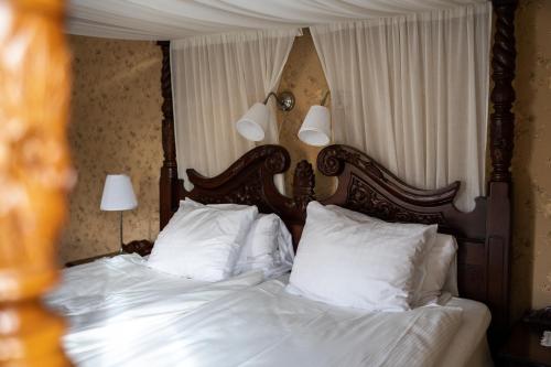 a bedroom with a bed with white sheets and pillows at Park Hotel Linköping Fawlty Towers in Linköping