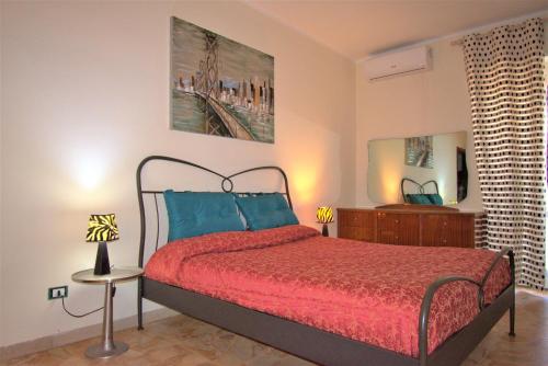 - une chambre avec un lit doté d'un couvre-lit rouge et d'oreillers bleus dans l'établissement Casa di Marta 50 meters from the sea, à Camaiore