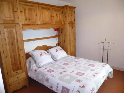 1 dormitorio con litera de madera y 2 almohadas en Les coquelicots, en Lhommaizé