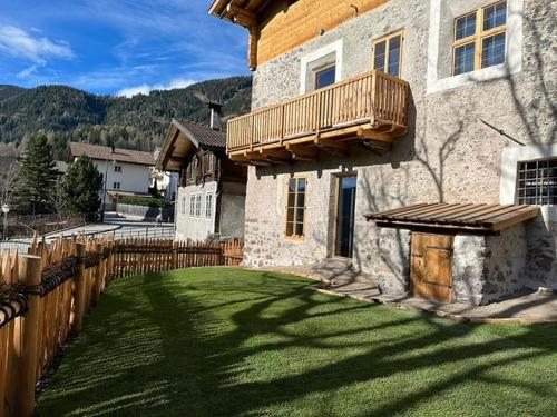 a house with a yard with a wooden fence at Alpin Chalet Samer Apt Fürstenblick in Sarntal