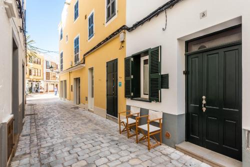 una calle en una ciudad con dos sillas frente a un edificio en Holiday Home Casa Sant Pere by Mauter Villas, en Ciutadella
