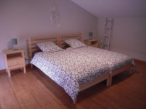 Un dormitorio con una cama y una escalera. en Gite du fournil, en Bouresse