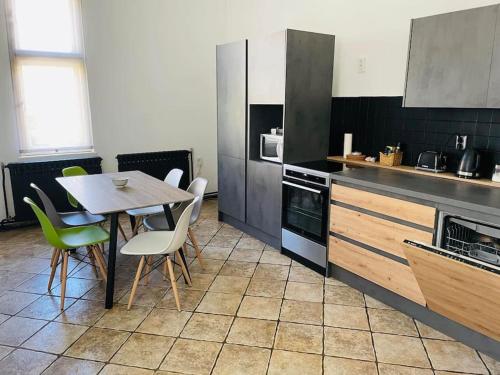 a kitchen with a table and chairs in a kitchen at Apartment Helios - self check in, strict center in Osijek