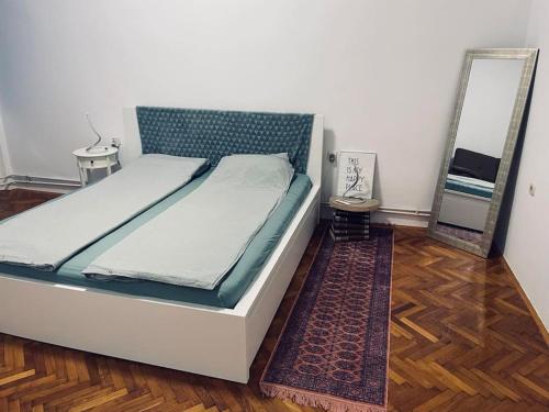 een slaapkamer met een bed met een spiegel en een tapijt bij Apartment Helios - self check in, strict center in Osijek