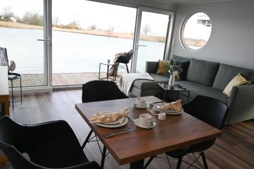 a living room with a table and a couch at Hausboot Kajüte am Nixensteg Am Wangermeer mit Hund in Wangerland