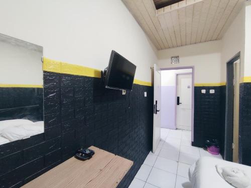 a room with a bed and a tv on a wall at Superstar Residence Tomohon Redpartner in Tomohon