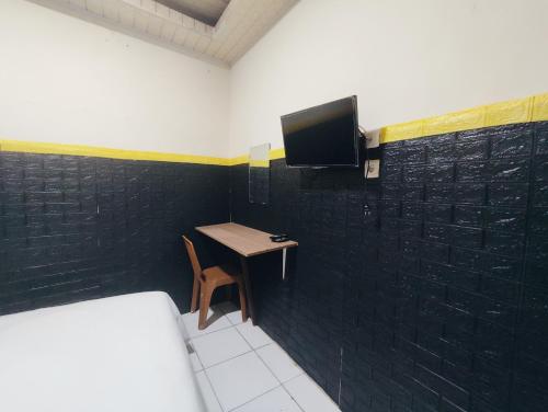 a room with a small table and a tv on a wall at Superstar Residence Tomohon Redpartner in Tomohon