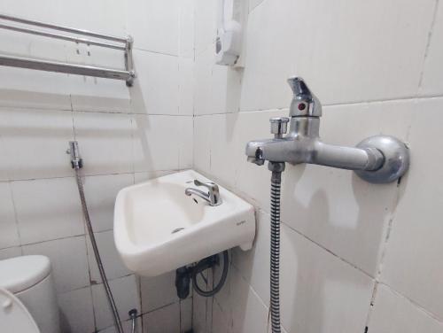 a white bathroom with a sink and a toilet at Superstar Residence Tomohon Redpartner in Tomohon