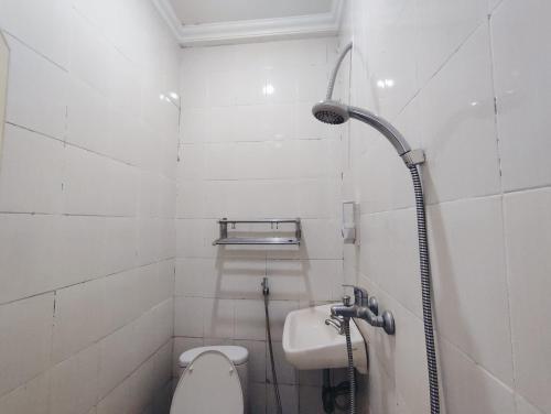 a bathroom with a shower and a toilet and a sink at Superstar Residence Tomohon Redpartner in Tomohon