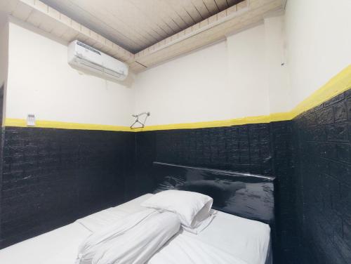 a bed in a room with a black wall at Superstar Residence Tomohon Redpartner in Tomohon