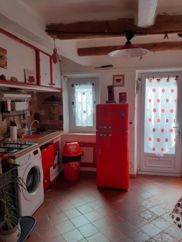 Il comprend une cuisine équipée d'un réfrigérateur rouge et d'un lave-linge. dans l'établissement Maisonnette Chez Thierry, à Marseille
