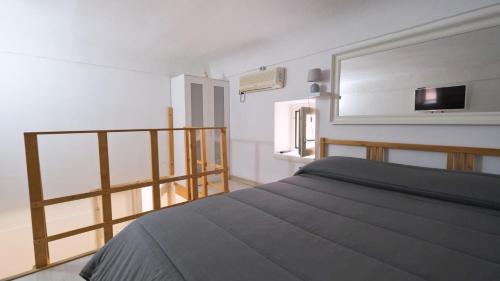 um quarto com uma cama e uma televisão na parede em Affittacamere B&B monolocale em Brindisi
