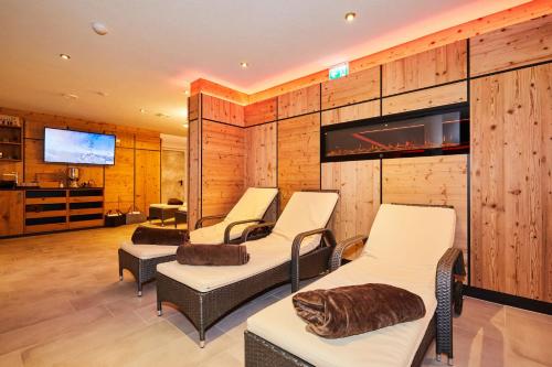 a room with four chairs and a flat screen tv at Das Salzburgblick in Ainring