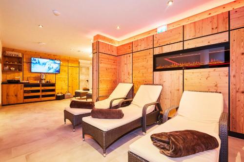a room with four chairs and a flat screen tv at Das Salzburgblick in Ainring