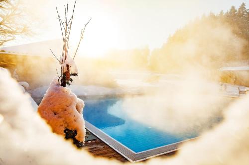 a hot tub with snow on it next to a pool at Das Salzburgblick in Ainring