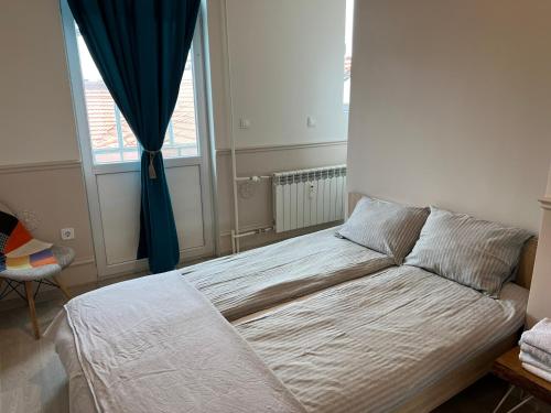 łóżko w sypialni z dużym oknem w obiekcie Vitosha 60 w mieście Sofia