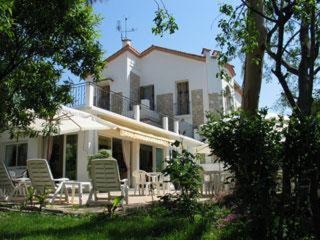 a large white house with lawn chairs in front of it at Hotel Pierre Loti in Juan-les-Pins