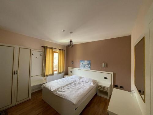 sypialnia z białym łóżkiem i oknem w obiekcie Hotel Margjeka w mieście Valbonë