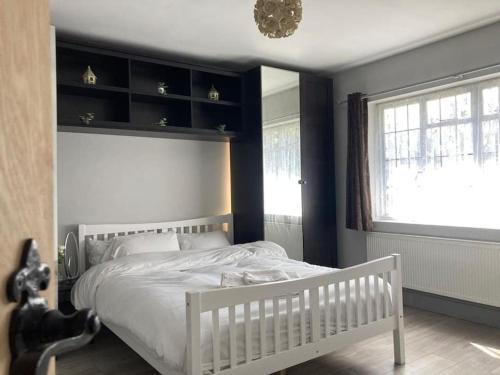 - une chambre avec un lit blanc et une fenêtre dans l'établissement Peaceful Home in Guildford Surrey UK -Free Parking, Garden, River & Waterfall, à Bramley