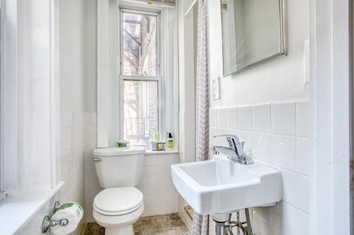 a white bathroom with a toilet and a sink at Cozy N End 2BR steps from Harborwalk BOS-445 in Boston