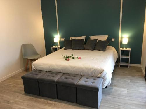 - une chambre avec un grand lit fleuri dans l'établissement Hibiscus la vallee des noyers, à Lhommaizé