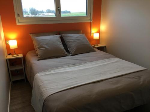 uma cama num quarto com dois candeeiros em ambos os lados em Mandarine la vallee des noyers em Lhommaizé