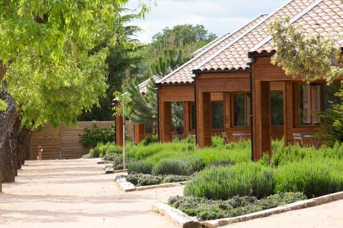 a wooden house with a garden in front of it at Vall d'Àger Resort & Camping in Ager