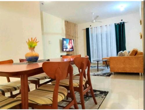 un soggiorno con tavolo, sedie e divano di MEDZAM HOMES BRILLIANT THREE BEDROOM ALL WITH OCEAN ViEW a Mombasa