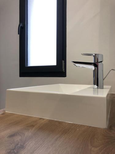 a sink with a faucet in front of a mirror at Les clés d'à côté - maison d'hôtes de charme près de Rouen in Sotteville-lès-Rouen