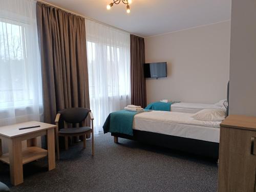 Habitación de hotel con cama y silla en Rewita Pieczyska, en Koronowo