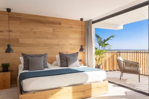 um quarto com uma cama e uma varanda em Las Gaviotas Suites Hotel & Spa em Playa de Muro