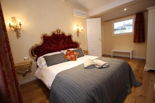a bedroom with a large bed with two towels on it at HomEdoApartments Deluxe Terme suite in Florence