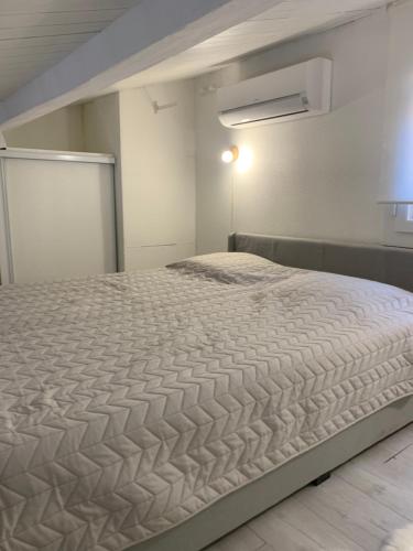 - une chambre avec un grand lit blanc dans l'établissement Mazet de vacances residence l espai, à Saint-Martin-de-Brômes