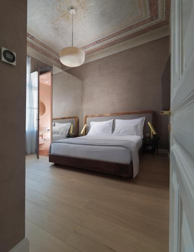 a bedroom with a large bed with white pillows at Monument Hotel in Athens