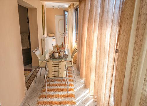 a dining room with a table and chairs and curtains at Stamoulis' house in Drakeia