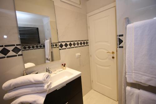 a white bathroom with a sink and a mirror at HomEdoApartments Deluxe Terme suite in Florence