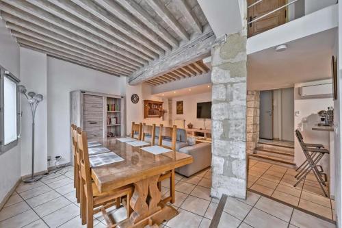 une cuisine et une salle à manger avec une table et des chaises en bois dans l'établissement Le Pagnol - WIFI - CLIM, à Avignon