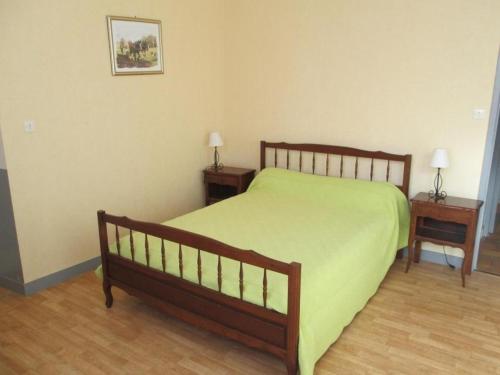 1 dormitorio con 1 cama verde y 2 mesitas de noche en Le marronnier, en Saint-Jean-de-Sauves