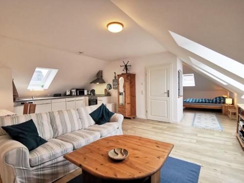 a living room with a couch and a table at Scholz-Riewerts - gemütliches Apartment mit Küche für 2 Personen in Silberstedt